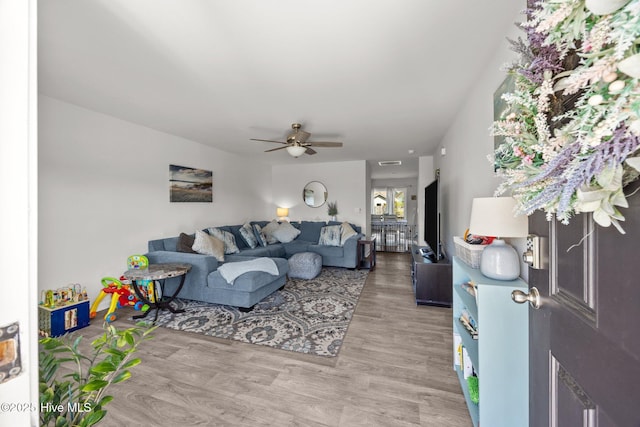 living area with ceiling fan and light wood finished floors
