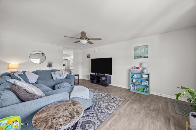 living area featuring ceiling fan, wood finished floors, and baseboards