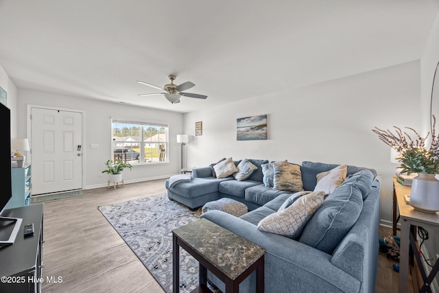 living room with a ceiling fan, wood finished floors, and baseboards