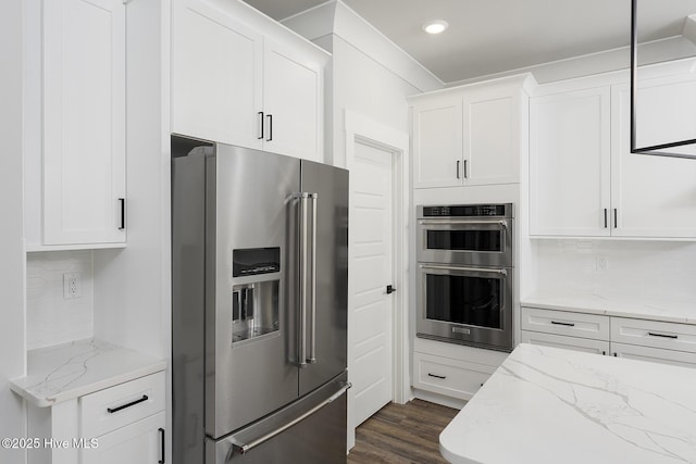 778 Hollybriar Loop Rd SE, Bolivia, NC 28422 - kitchen featuring appliances with stainless steel finishes, white cabinetry, tasteful backsplash, light stone counters, and dark wood-type flooring