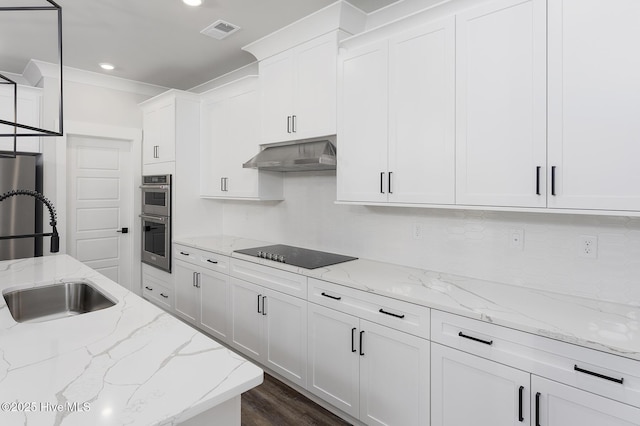 778 Hollybriar Loop Rd SE, Bolivia, NC 28422 - kitchen with black electric cooktop, under cabinet range hood, double oven, a sink, and white cabinets