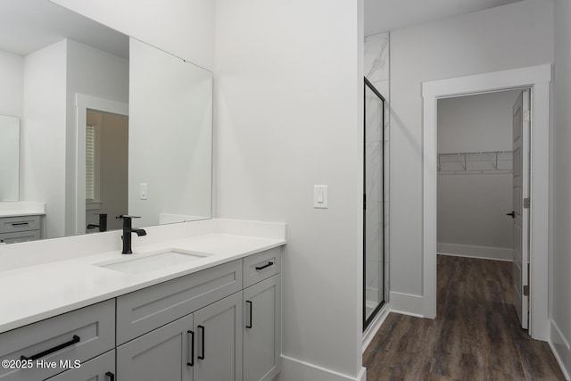 778 Hollybriar Loop Rd SE, Bolivia, NC 28422 - bathroom with a stall shower, vanity, a walk in closet, and wood finished floors