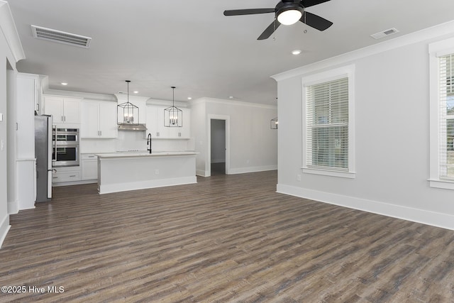 778 Hollybriar Loop Rd SE, Bolivia, NC 28422 - unfurnished living room with recessed lighting, a ceiling fan, dark wood-style flooring, baseboards, and ornamental molding