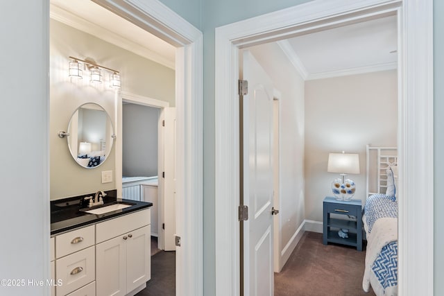 bathroom featuring crown molding, vanity, and baseboards