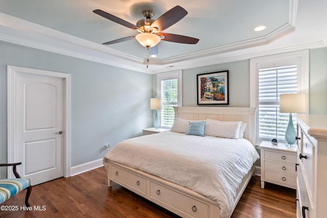 bedroom with a tray ceiling, ornamental molding, dark wood-style flooring, a ceiling fan, and recessed lighting