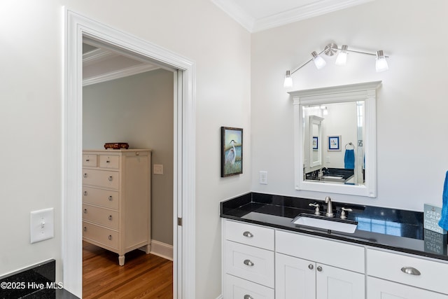 bathroom with crown molding, wood finished floors, and vanity