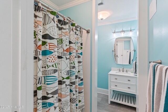 full bathroom with crown molding, wood finished floors, vanity, a shower with curtain, and baseboards
