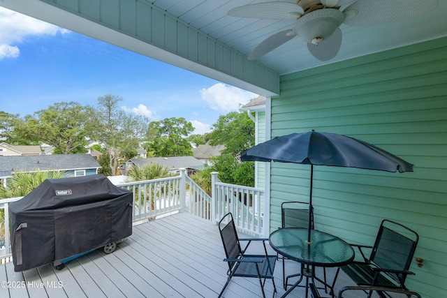 wooden deck with a ceiling fan, a grill, and outdoor dining area