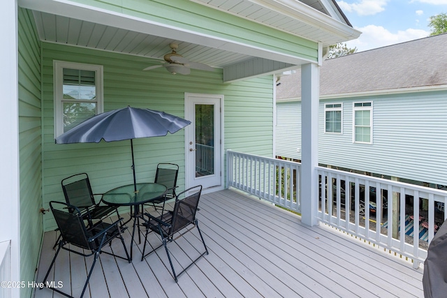 wooden terrace with ceiling fan and outdoor dining space