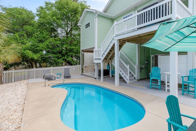 view of swimming pool featuring stairs, a wooden deck, a patio area, and fence