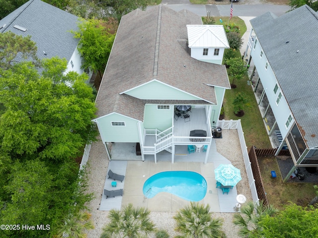 back of property featuring roof with shingles, a fenced backyard, a deck, and a patio