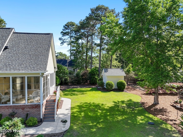 view of grassy yard with an outdoor structure, a shed, stairway, and a sunroom