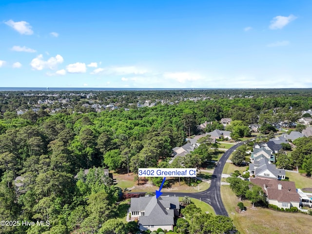 aerial view of property's location with a forest and nearby suburban area