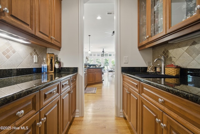 127 Meherrin River Dr, Hertford, NC 27944 - kitchen featuring decorative backsplash, a sink, light wood finished floors, and brown cabinetry