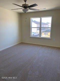 carpeted empty room with a ceiling fan and baseboards