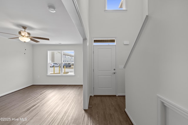 entrance foyer featuring dark wood-style flooring, a ceiling fan, and baseboards