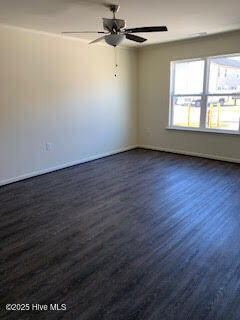 unfurnished room featuring dark wood finished floors and ceiling fan