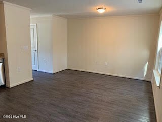 unfurnished room with dark wood finished floors and baseboards