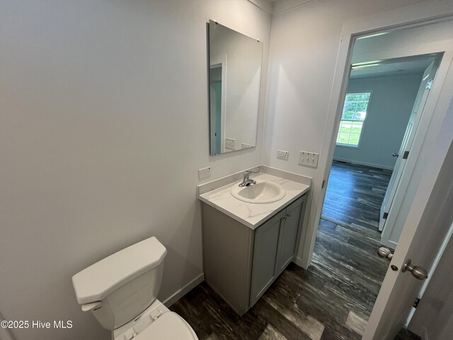 6243 NC Highway 58, Stantonsburg, NC 27883 - bathroom with toilet, wood finished floors, vanity, and baseboards