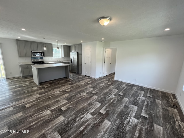 6243 NC Highway 58, Stantonsburg, NC 27883 - kitchen featuring appliances with stainless steel finishes, gray cabinets, dark wood-type flooring, a kitchen island, and recessed lighting