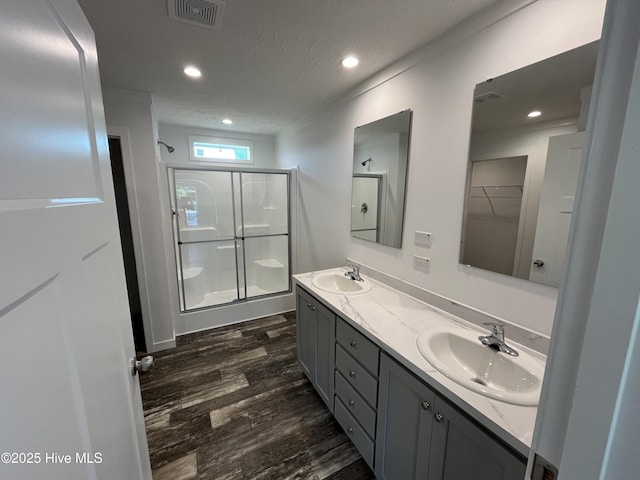 6243 NC Highway 58, Stantonsburg, NC 27883 - bathroom with a stall shower, wood finished floors, double vanity, recessed lighting, and a textured ceiling