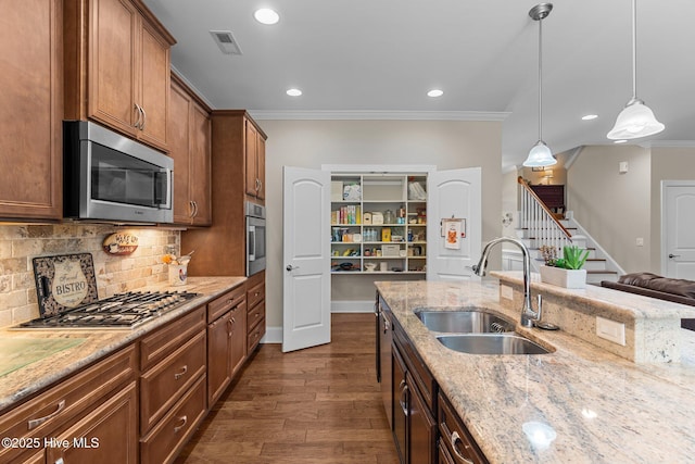 kitchen with a sink, stainless steel appliances, crown molding, dark wood-type flooring, and decorative backsplash