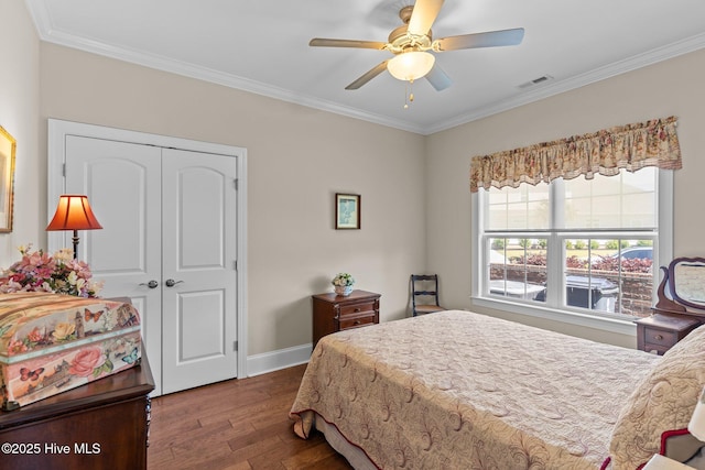 bedroom featuring wood finished floors, ornamental molding, a closet, baseboards, and ceiling fan