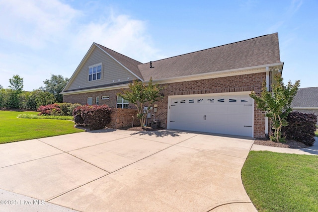 view of front of home with brick siding, driveway, a front lawn, a garage, and a shingled roof