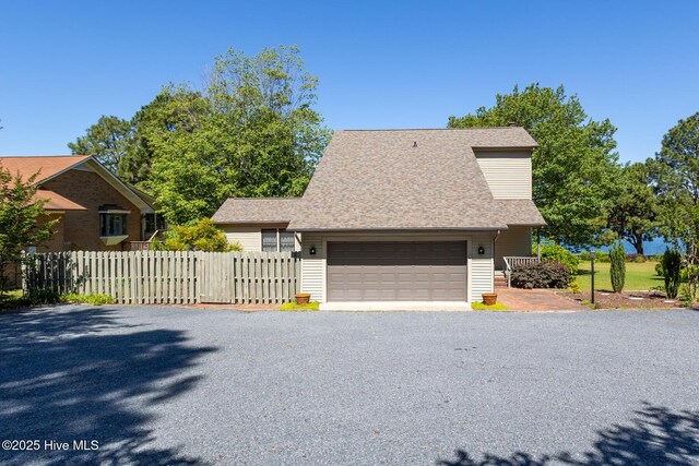 154 Overlook Dr, West End, NC 27376 - view of side of home with a garage, fence, asphalt driveway, and a shingled roof