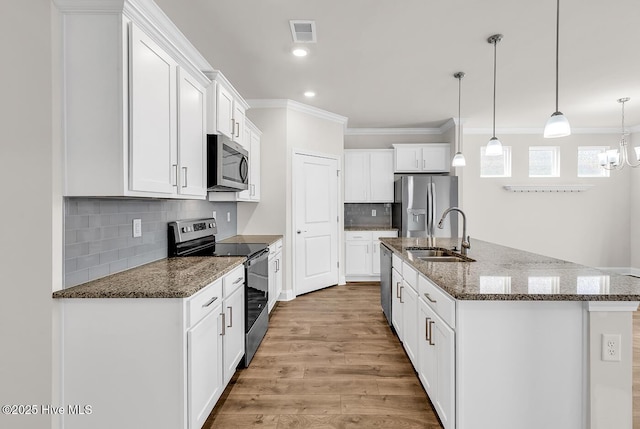 kitchen featuring appliances with stainless steel finishes, a sink, crown molding, light wood finished floors, and white cabinetry
