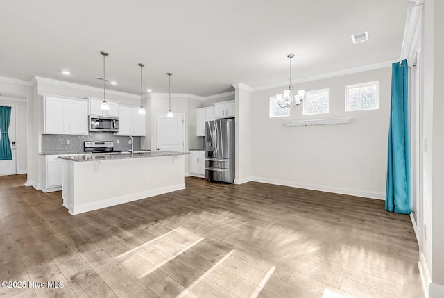 kitchen with appliances with stainless steel finishes, a chandelier, dark wood-style flooring, a center island with sink, and recessed lighting