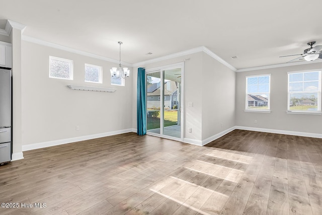 unfurnished dining area with a chandelier, wood finished floors, ceiling fan, baseboards, and crown molding