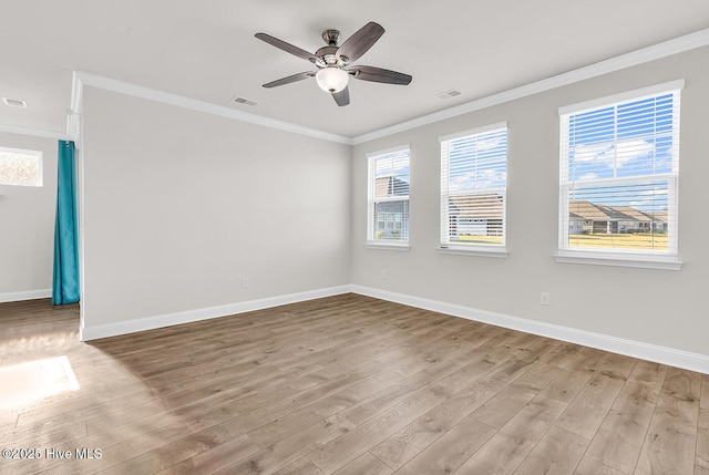 spare room featuring wood finished floors, crown molding, baseboards, and a ceiling fan