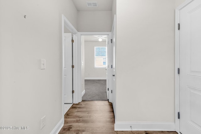 hall featuring wood finished floors and baseboards
