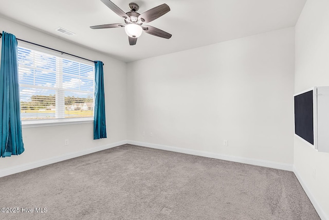 unfurnished room featuring carpet floors, a ceiling fan, and baseboards
