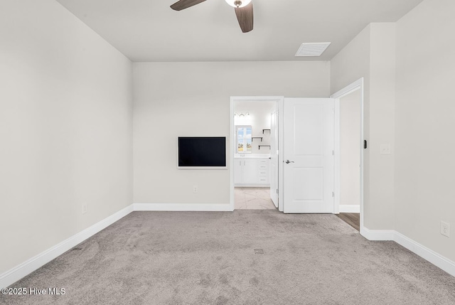 unfurnished bedroom with carpet flooring, baseboards, ensuite bath, and ceiling fan