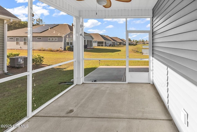 unfurnished sunroom with a residential view and ceiling fan
