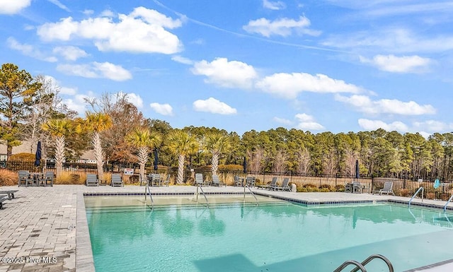 community pool featuring fence and a patio area