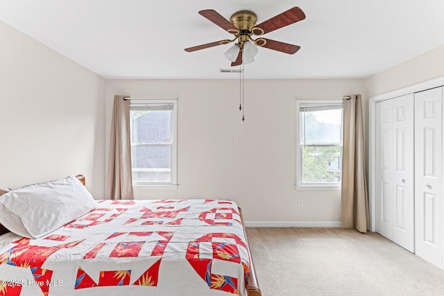 carpeted bedroom with baseboards, ceiling fan, and a closet