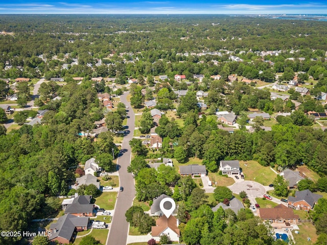 view of property location featuring a heavily wooded area and nearby suburban area