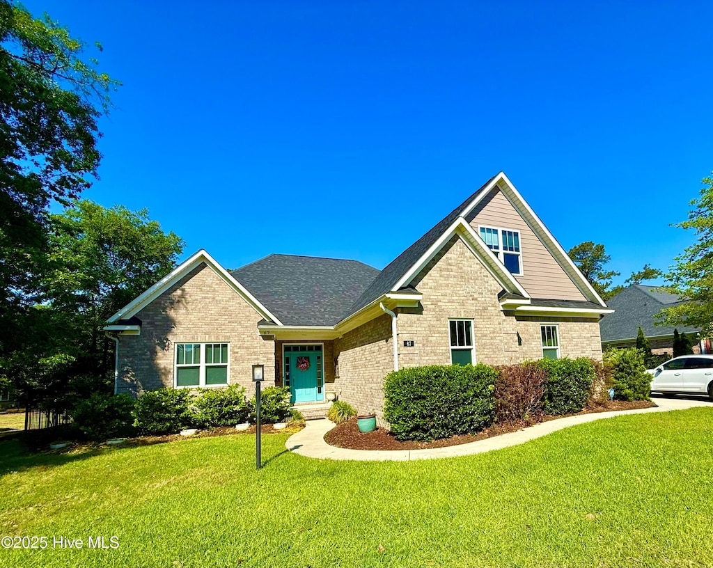 67 Westminster Way, Hampstead, NC 28443 - view of front of property with brick siding, a front lawn, and roof with shingles