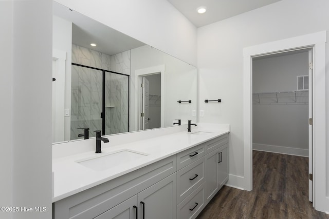 157 Bremerton Dr SE, Bolivia, NC 28422 - bathroom with double vanity, a spacious closet, a marble finish shower, wood finished floors, and recessed lighting