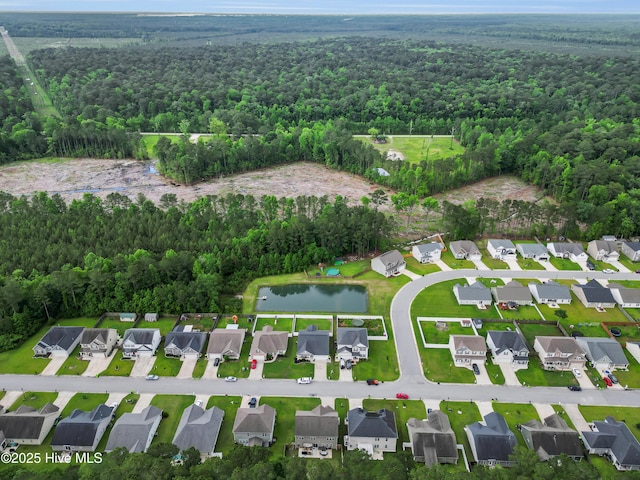 aerial view of property's location with a heavily wooded area, a large body of water, and nearby suburban area