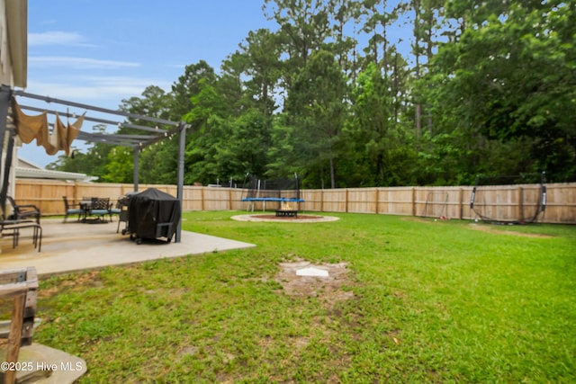 view of yard featuring a trampoline, a patio area, and a pergola