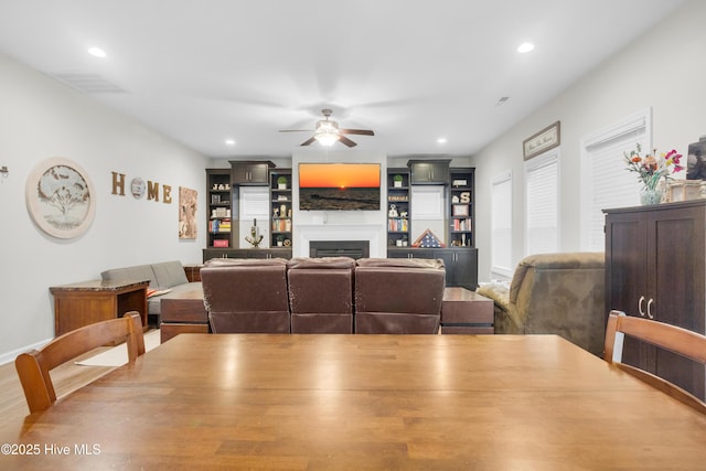 dining space with a ceiling fan, a fireplace, and recessed lighting