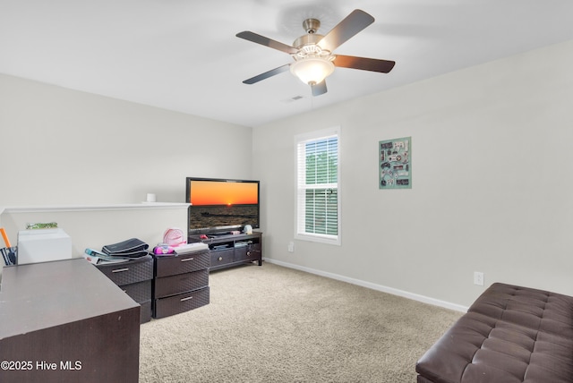 office space with light colored carpet, ceiling fan, and baseboards