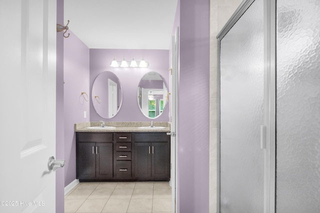 bathroom featuring a shower stall, tile patterned floors, and double vanity