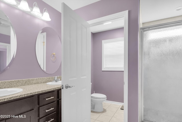 bathroom featuring toilet, a shower stall, tile patterned flooring, and double vanity