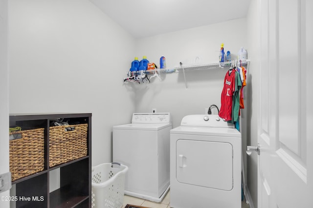 laundry room with independent washer and dryer and light tile patterned floors