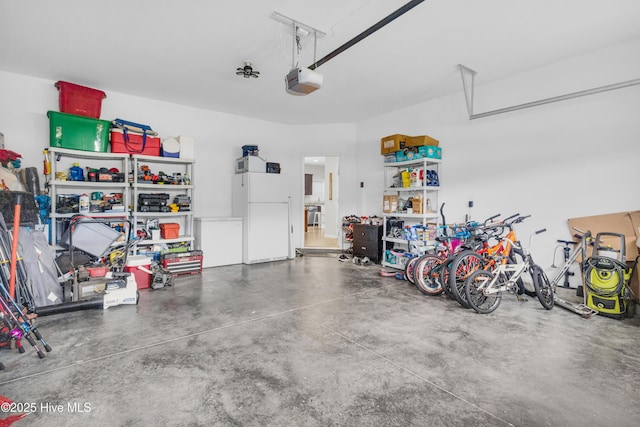 garage featuring freestanding refrigerator and a garage door opener